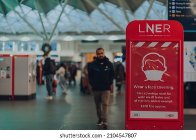 London, UK - January 01, 2022: Wear A Face Mask Sign On A LNER Board Inside The Hall Of Kings Cross Train Station. The Requirements Were Introduced Due To Coronavirus Pandemic. 