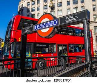 London, UK - January 28th 2019: The London Underground Sign At An Entrance To Monument Station With A Red London Bus In The Background In London, UK.