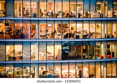 London, UK - January 31, 2013: people work in an office building at night. Windows interior. Concept for employment, business, corporate, working,brexit, business people, modern life, busy people