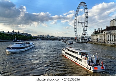 LONDON, UK - JULY 1, 2014: View of Thames river with cruise tour boats near the giant Ferris wheel nicknamed London Eye.Thames is the longest river in England with the length of 346 km.