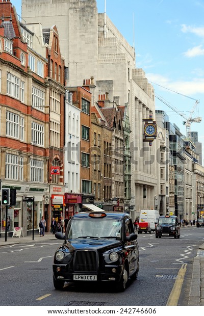 LONDON, UK - JULY 1,\
2014: The iconic black cab on Fleet street in London. A street in\
the City of London, which used to be home of British national\
newspapers until 1980s.