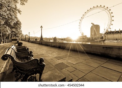 LONDON, UK -  JULY 18,2016. Empty bench and London Eye at sunrise in London, UK