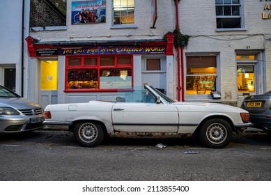 London, UK. July 20, 2021. Old Vintage Car Parked At Roadside In Front Of Dover Adventure Backpackers And A Restaurant In Building