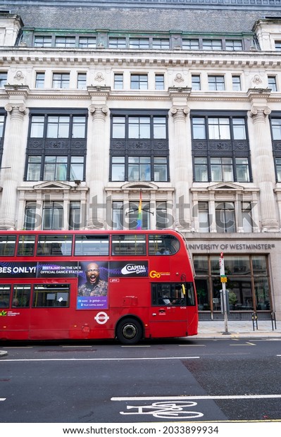 London, U.K., July 23,2021 - Red double decker\
english bus in front of University of Westminster building in\
London, street view