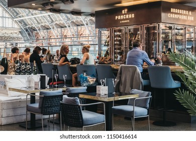 London, UK - July 26, 2018: People sitting at a bar inside St. Pancras station, one of the largest railway stations in London and a home to Eurostar. - Shutterstock ID 1150416614