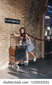 London, UK - July 26, 2018: People Taking Photos By 9 3/4 Platform Inside King's Cross Station, London, Station Where Students Of Hogwarts School Catch The Hogwarts Express.