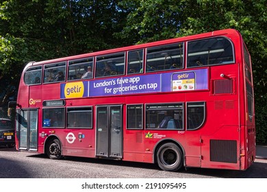 London, UK - July 5, 2022: Red Double Decker Public Bus With Ad On Side For Getir On Albany Street, Green Foliage In Back.