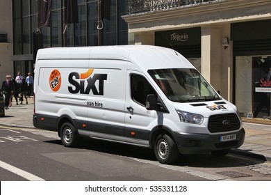 LONDON, UK - JULY 6, 2016: People walk by a Sixt van for hire, a Ford Transit. Sixt has some 4,000 locations in over 105 countries.