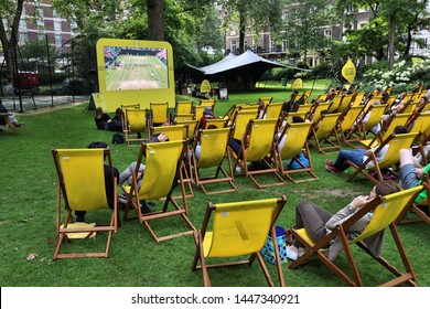 LONDON, UK - JULY 7, 2016: People Enjoy Public Wimbledon Tennis Tournament Broadcast In Grosvenor Square Park Of London, UK.