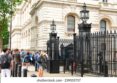 LONDON, UK - JULY 9, 2014: Tourists gather outside 10 Downing Street in London, the official residences of the Prime Minister of the UK