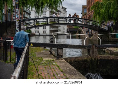 London, UK - Jun 09 2022: Senior man standing by the rail while watching a bridge at Regent's canal; London everyday life street photography wallpaper 
