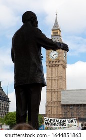 London, UK - June 11, 2010: Silhouette Of Nelson Mandela Statue At Parliament Square, With Big Ben In The Clock Tower And Banner Of Strikers In London, Great Britain