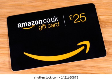 London, UK - June 11th 2019: An Amazon gift card for £25 pictured on a wooden surface.