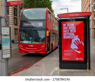 London, UK - June 17th 2020: A London bus at a bus stop during the Coronavirus pandemic, with a billboard displaying a sign informing commuters that the buses are cleaned with Antiviral disinfectant.