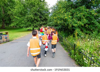 London, UK - June 21, 2018: St James Park Green Trees In Summer With Many Crowd Of People School Children Walking On Sidewalk Road On Field Trip In Vests