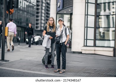 London, UK - June 21, 2022: Two young girls with travel bags are crossing the road in the City of London. Commuters, office workers, City of London life, Street photography