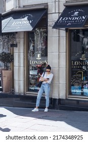 London, UK - June 21, 2022: Young woman waiting someone in the City of London. Commuters, office workers, City of London life, Street photography