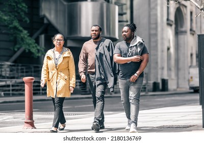 London, UK - June 21, 2022: Group of young people are walking in the City of London street. City of London financial and business area life, street photography