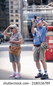 London, UK - June 21, 2022: Elderly people walking and and make photos in the City of London. City of London financial and business area life, street photography
