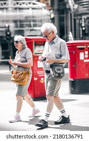 London, UK - June 21, 2022: Elderly people walking and and make photos in the City of London. City of London financial and business area life, street photography