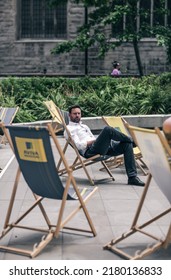 London, UK - June 21, 2022: Young businessman relaxing in the City of London square. City of London financial and business area life, street photography