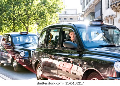 London, UK - June 22, 2018: Closeup Of Expensive Black Taxi Cab And Driver On Street Road, Young Man Behind Wheel Waiting In Traffic