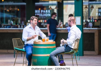 London, UK - June 22, 2022: Group Of Young Professional People  Having A Chat In Park Cafe In The City Of London. Business Life In The City.