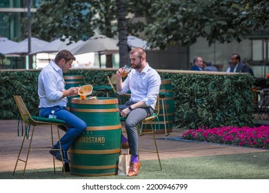 London, UK - June 22, 2022: Group Of Young Professional People  Having A Chat In Park Cafe In The City Of London. Business Life In The City.