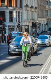 London, UK - June 22, 2022: Young Woman Cycling At Work By Bike. People Cycling Into The City Of London