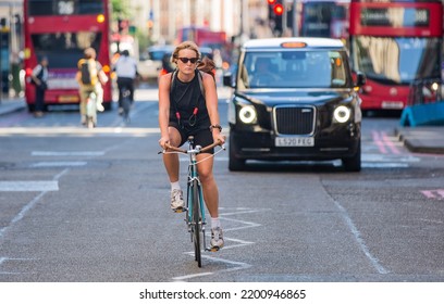 London, UK - June 22, 2022: Young Woman Cycling At Work By Bike. People Cycling Into The City Of London