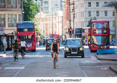 London, UK - June 22, 2022: Young Woman Cycling At Work By Bike. People Cycling Into The City Of London