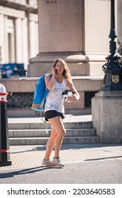 London, UK - June 22, 2022: Young Woman With Rucksack Is Walking In  The City Of London. People Rush At Work 