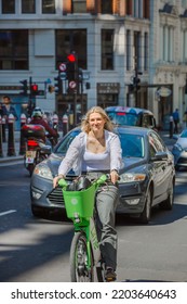 London, UK - June 22, 2022: Young Woman Cycling At Work By Bike. People Cycling Into The City Of London