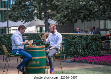 London, UK - June 22, 2022: Group Of Young Professional People  Having A Chat In Park Cafe In The City Of London. Business Life In The City.