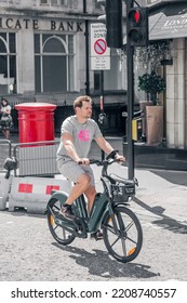 London, UK - June 22, 2022: Young Woman Cycling At Work By Bike. People Cycling Into The City Of London