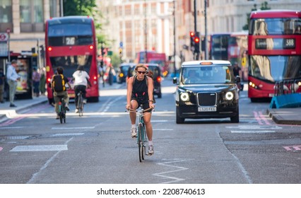 London, UK - June 22, 2022: Young Woman Cycling At Work By Bike. People Cycling Into The City Of London