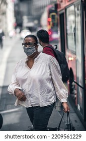 London, UK - June 22, 2022: Woman In Face Mask Gets Out Of The Bus In The City Of London