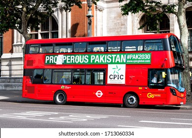 London, UK - June 24, 2018: Red double decker bus on street road in downtown city with advertisement sign for prosperous pakistan