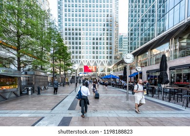 London, UK - June 26, 2018: People Crowd Commuters Outside During Morning Commute In Canary Wharf Docklands With Modern Architecture, Clocks Time, Restaurant