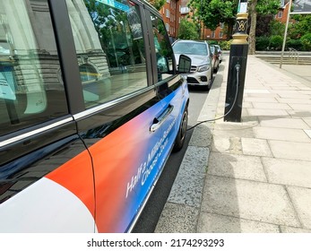 London, UK - June 27th 2022; Electric London Taxi Recharging On The Roadside From A Lamppost Socket.