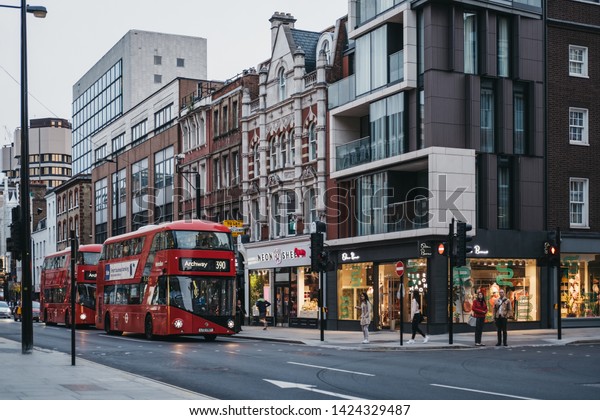 London, UK - June 5, 2019:\
Red double decker buses and cars on Tottenham Court Road, London,\
in the evening. Buses are an integral part of Transport for London\
network.