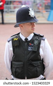 London, UK - June 6th 2019: Police Man Watches Crowd In Helmet And Vest, Also Known As British Bobby- Stock Photo