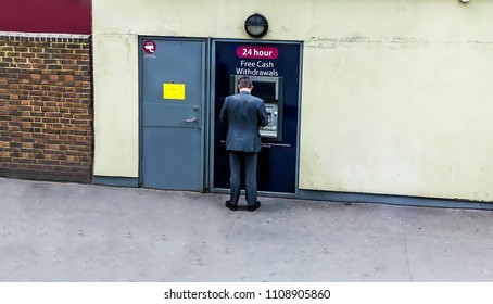 LONDON, UK - JUNE 9, 2015: Man Using His Credit Card In An Atm For Cash Withdrawal