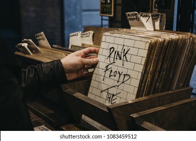 London, UK - March 10, 2018: Man looking through music posters on sale at Covent Garden Market, one of the oldest markets in London famous for its unique handmade crafts. 