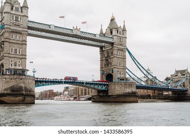 London, UK - March 16, 2019;
Tower Bridge view from River Thames on the cloudy day, double-decker bus is crossing the Bridge. Tower Bridge is a combined bascule and suspension bridge in London.