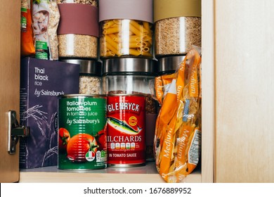 London, UK: March 18, 2020: Cupboard shelves fool of food provision, such as pasta, rice, porridge, canned tuna, beans and more. Panic buying to survive Coronavirus COVID 19 pandemic during lock down.