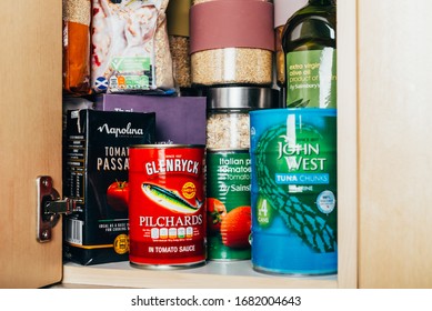 London, UK: March 18, 2020: Cupboard shelves fool of food provision, such as pasta, rice, porridge, canned tuna, beans and more. Panic buying to survive Coronavirus COVID 19 pandemic during lock down.