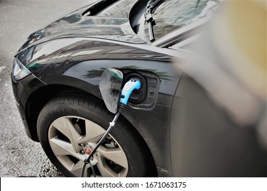 London, UK / March, 2020 / A Electric Car Is Plugged In Charging On A Off-street Charging Point. Good Close Up Of The Vehicle Plugged In, Shows Plug Cable Going Away From The Vehicle 