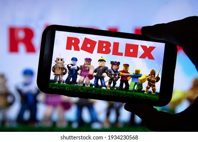 LONDON, UK - March 2021: Person Holding A Smartphone With Roblox Game Logo