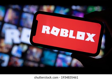 LONDON, UK - March 2021: Person Holding A Smartphone With Roblox Game Logo